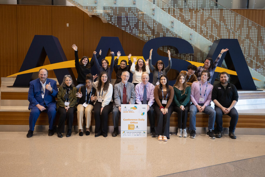 Conference Daily Online staff in front of big AASA letters, silly photo